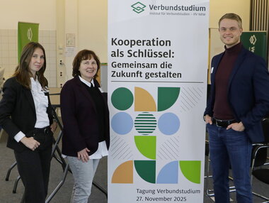 Foto:Drei Personen vor dem Tagungs Roll-up